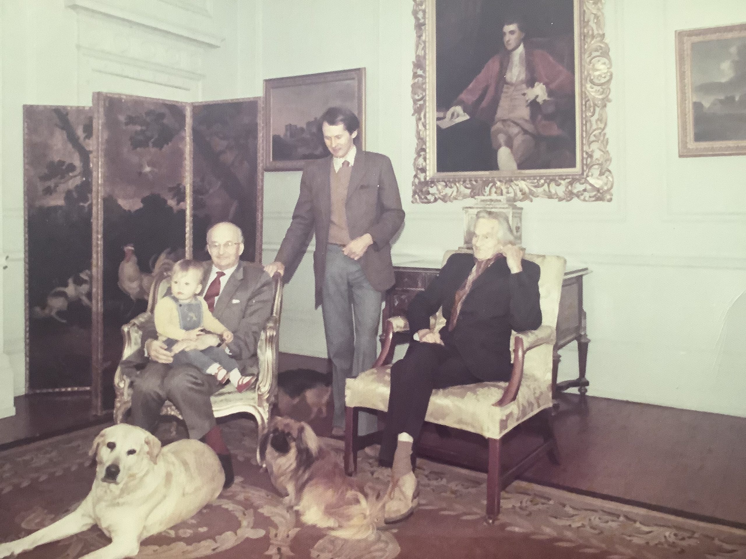 In 1975, four generations of FitzGeralds gathered at Langston House, Chadlington, Chipping Norton, Oxfordshire. L-R: Gerald (8th Duke of Leinster), with his grandson Thomas on his lap, seated near his father, the 7th Duke, with Maurice, the present duke standing in between. Joshua Reynolds’s portrait of the 2nd Duke is on the wall behind them.