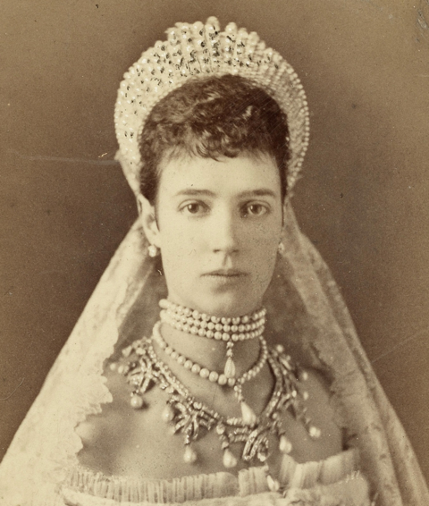 Tsarina Maria Feodorovna (Dagmar of Denmark), Empress consort of Russia, in 1881. She is wearing the Imperial Russian court dress and a diadem with pearls and a lace veil, and necklaces.